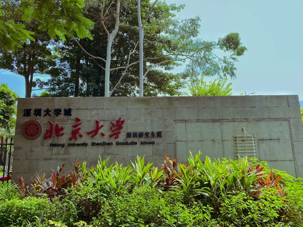 a sign in front of some bushes and trees